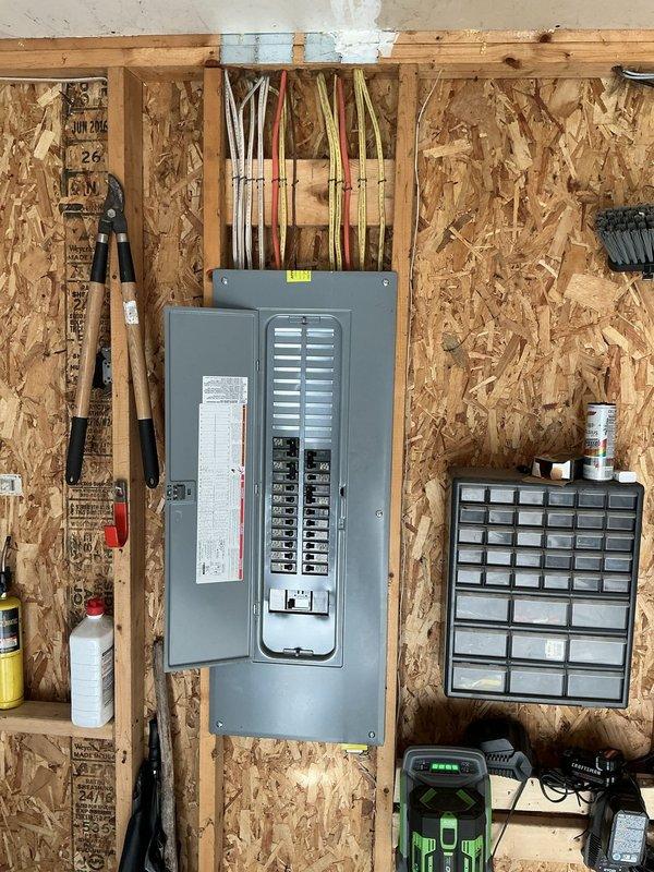 Conducted estimate for mini-split system evaluation at residential property. Assessed existing Fujitsu outdoor condenser unit mounted on exterior wall with visible wear to surrounding siding and electrical disconnect box area. Evaluated electrical panel capacity and configuration in unfinished interior space to determine compatibility for potential system upgrades or modifications, noting current breaker arrangement and available capacity for additional HVAC equipment installation.
