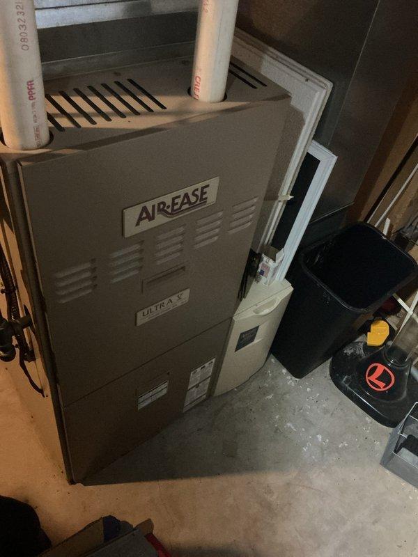 Responded to service call for HVAC system experiencing loud fan noise and ice buildup on evaporator coil. Upon arrival, inspected 16-year-old Air-Ease Ultra V furnace unit installed in basement. Confirmed excessive noise from blower assembly and visible ice formation on indoor coil, indicating restricted airflow. Performed system diagnostics to identify root cause of freezing condition. Checked air filter status, verified proper blower operation, and examined ductwork connections for obstructions or airflow restrictions. Documented equipment condition with photographs showing furnace installation, ductwork configuration, and overall system layout. Addressed airflow deficiency causing coil to freeze and generating abnormal fan noise during operation.