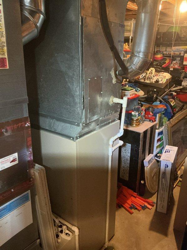 Responded to service call for HVAC system experiencing loud fan noise and ice buildup on evaporator coil. Upon arrival, inspected 16-year-old Air-Ease Ultra V furnace unit installed in basement. Confirmed excessive noise from blower assembly and visible ice formation on indoor coil, indicating restricted airflow. Performed system diagnostics to identify root cause of freezing condition. Checked air filter status, verified proper blower operation, and examined ductwork connections for obstructions or airflow restrictions. Documented equipment condition with photographs showing furnace installation, ductwork configuration, and overall system layout. Addressed airflow deficiency causing coil to freeze and generating abnormal fan noise during operation.