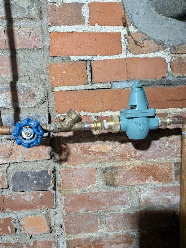 Replaced defective pressure reducing valve on exterior water supply line. Removed old pressure regulator and installed new unit inline with existing copper piping, gate valve, and Y-strainer assembly. System tested and verified proper pressure regulation upon completion.