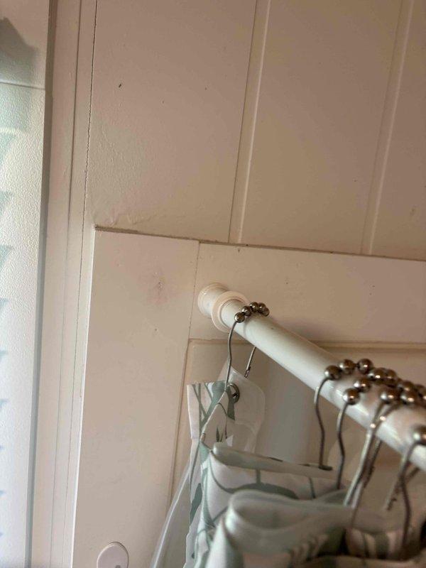 Conducted on-site assessment for plumbing project estimate involving installation of handheld shower attachment to existing bathtub and mounting of grab bars in single-family residence bathroom. Evaluated existing shower curtain rod configuration, wall paneling condition, and structural mounting points for safety bar installation. Documented current bathroom setup including beadboard paneling and identified suitable locations for hardware installation while ensuring proper wall support and code compliance for grab bar placement.