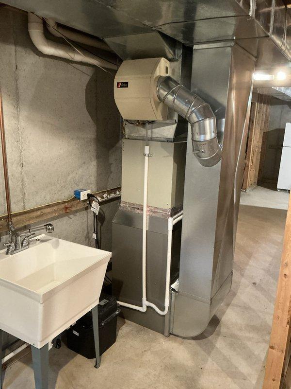 Completed estimate for residential air conditioning system evaluation in basement mechanical room. Homeowner expressed concerns about AC unit potentially being undersized and nearing end of service life. Inspection revealed existing Carrier furnace with connected ductwork and separate cooling system components; confirmed previous service records show furnace replacement only, while AC unit remains original to home. Documented current equipment configuration, ductwork layout, and system specifications with photos for estimate preparation. Applied veteran discount to proposed replacement options.