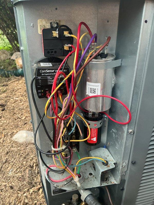 # NC-No Cool Service Completed

Responded to a no cooling call on an outdoor HVAC condensing unit. Upon arrival, performed diagnostic testing on the electrical system. Found failed run capacitor showing significant corrosion, surface deterioration, and electrical failure. Removed defective capacitor and associated components from the unit for testing and replacement. Installed new run capacitor with proper electrical connections to contactor and CoreSense monitoring system. Verified all wire terminations were secure and properly routed within the control panel. Tested system operation and confirmed unit returned to normal cooling function. Unit operating within manufacturer specifications at time of departure.