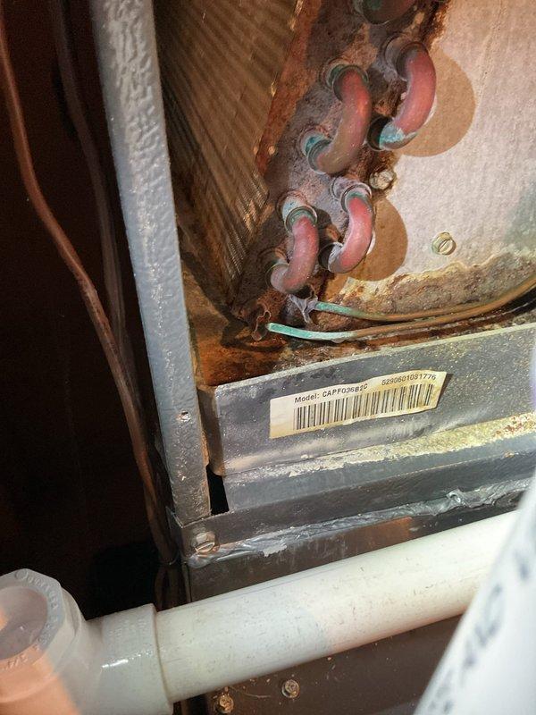 Responded to no cooling complaint on 15-year-old air conditioning system. Upon arrival, performed diagnostic inspection of the unit and associated components. Documented existing conditions including significantly corroded copper refrigerant lines and fittings showing advanced oxidation with green patina formation, indicating extended exposure to moisture and age-related deterioration. Observed water staining and rust streaks on internal metal panels near pipe connections, suggesting potential historical moisture intrusion. Photographed deteriorated plumbing connections, corroded pipe assemblies, and overall system condition for documentation purposes.