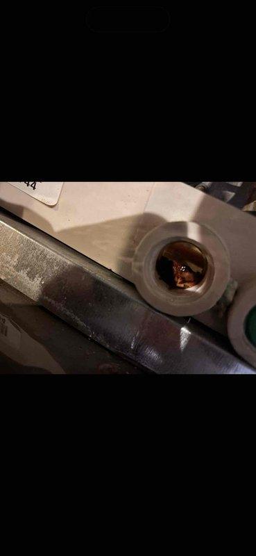 Responded to water leak caused by broken condensate drain pipe on 14-year-old Rheem HVAC unit. Upon arrival, found the white PVC condensate pipe elbow fitting had separated from the system, resulting in active water discharge onto the equipment and surrounding area. Repaired the damaged condensate drain connection, restored proper drainage function, and verified system operation. Documented existing moisture on metal panels and components due to the leak prior to repair.