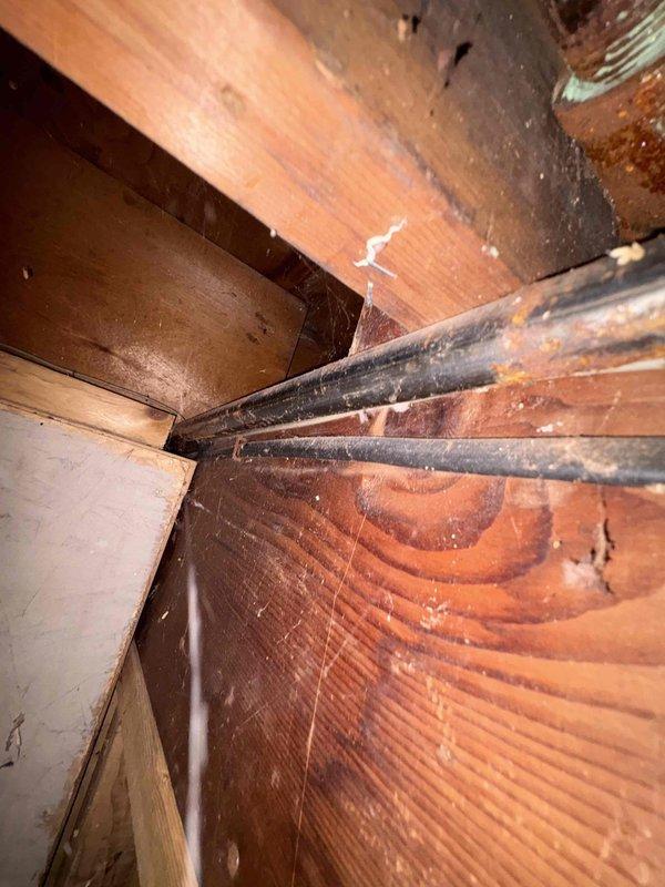 Installed new gas line from furnace location through attic crawlspace to building exterior. Routed black iron pipe through confined attic space, navigating around existing HVAC ductwork and structural framing members. Installation completed per code requirements for residential gas piping.