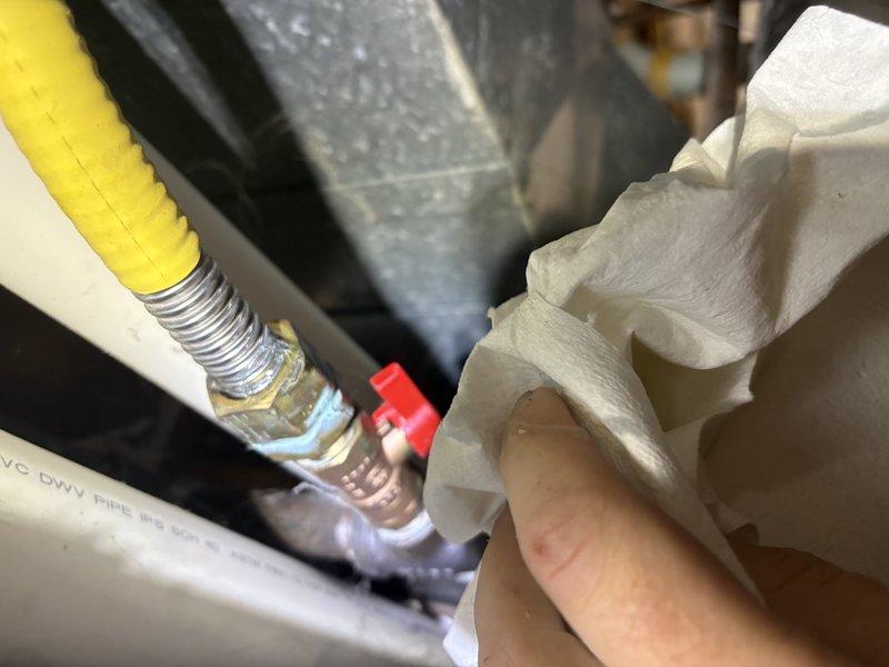 Responded to gas leak call near furnace location. Upon arrival, utilized refrigerant leak detector with flexible probe to systematically inspect HVAC components, ductwork, and gas line connections in mechanical area. Identified leak at flexible corrugated gas line connection point near furnace. Inspected associated plumbing components, PVC piping, and metal fittings in the vicinity. Applied leak detection solution to verify exact location of gas escape at connection fitting. Documented conditions with photographs for service records.