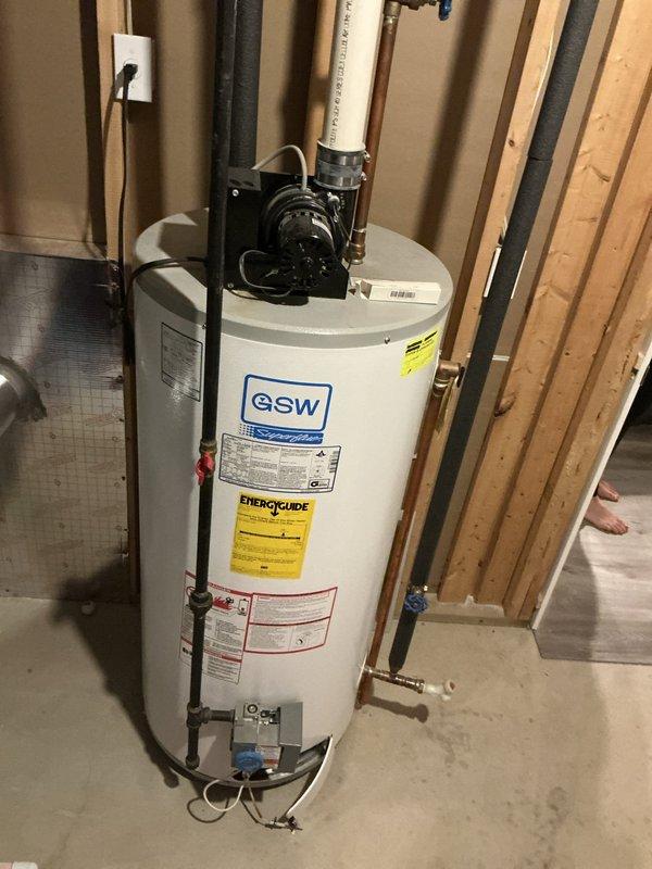 Conducted water heater replacement estimate for single-family residence with 23-year-old GSW tank-style unit showing signs of failure. Inspected existing installation in basement utility area, documented current plumbing configuration including copper supply lines, PVC venting, and drain connections. Provided comprehensive quotes for both traditional tank-style and tankless water heater replacement options per customer request.