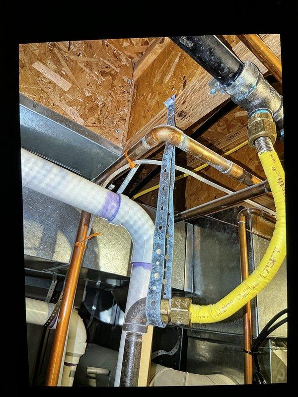 Completed inspector-required corrections on water heater gas line installation. Corrected kinked yellow CSST flexible gas line at fitting by reinstalling with proper bend radius per manufacturer specifications. Installed additional support and securing for 1/2" gas drop line to meet code requirements. Documented corrected work with photos for inspector review.