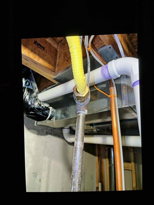 Completed inspector-required corrections on water heater gas line installation. Corrected kinked yellow CSST flexible gas line at fitting by reinstalling with proper bend radius per manufacturer specifications. Installed additional support and securing for 1/2" gas drop line to meet code requirements. Documented corrected work with photos for inspector review.