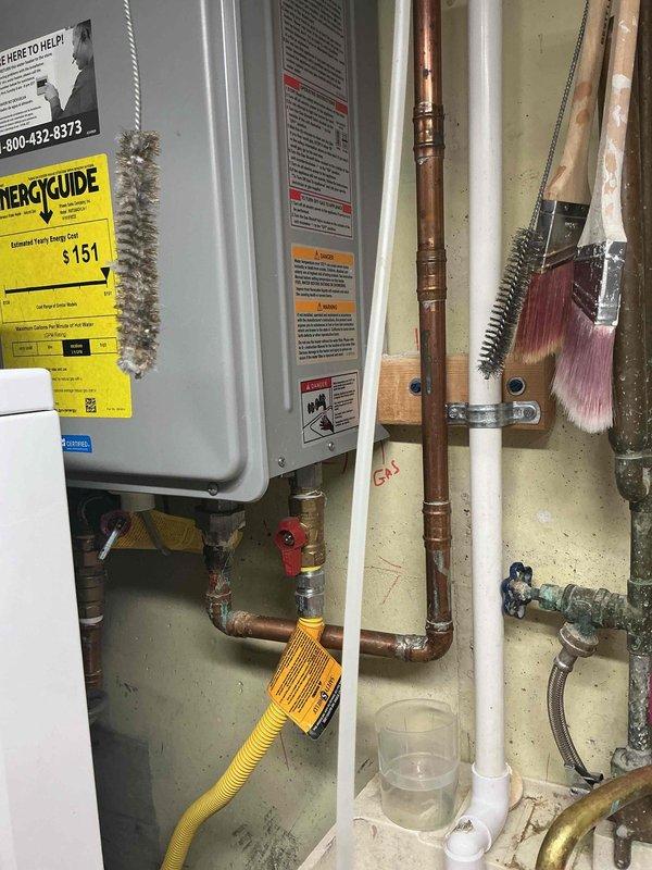 Performed comprehensive tankless water heater tune-up and flush service on unit approximately 5 years old. Completed descaling procedure using isolation valves and flushing equipment to remove mineral buildup from heat exchanger, cleaned inlet filter screen, verified proper operation of gas supply line and connections, and confirmed all plumbing components including copper piping and shut-off valves were functioning correctly.