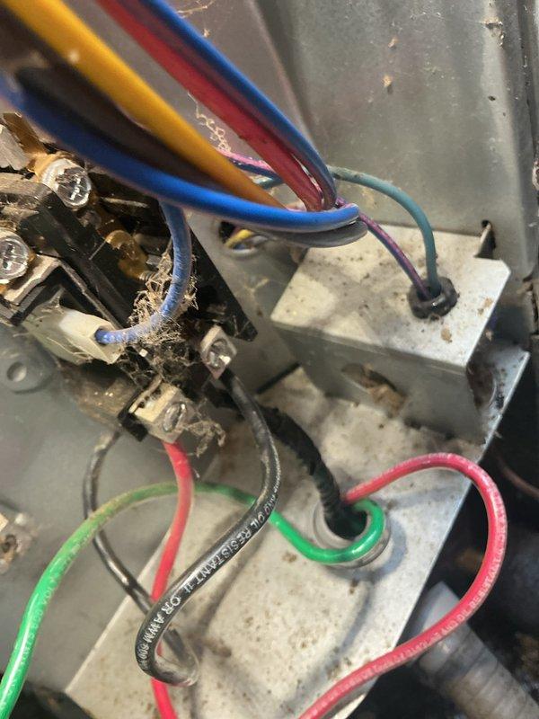 Responded to service call for air conditioning system repeatedly tripping circuit breaker at single-family residence. Unit is approximately 5 years old. Upon arrival, performed visual inspection of outdoor condensing unit and electrical components.

Inspection revealed significant accumulation of dirt, dust, and debris on condenser unit components and electrical connections. Examined refrigerant line connections and service ports, noting environmental contamination on exterior surfaces. Inspected electrical terminal block and wiring connections, observing heavy dust buildup and debris accumulation around wire terminations and connection points. Multiple conductor wires showed signs of age-related discoloration and environmental exposure.

Identified potential electrical issues related to compromised connections and contamination that could cause intermittent breaker trips. Terminal block showed signs of extended service with visible grime deposits around connection points. Black insula