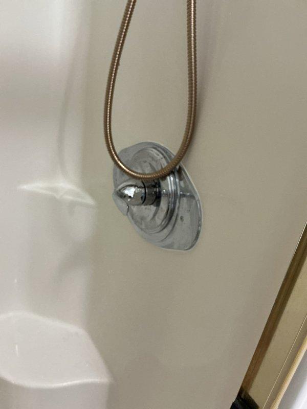 Completed shower valve replacement in bathroom. Removed existing fixture and installed new chrome-plated shower arm with wall flange, ensuring proper threading and seal to prevent leaks. Connected flexible metal supply hose to new valve assembly and verified water flow and temperature control functionality upon completion.