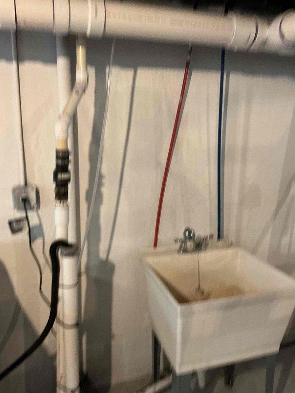 Responded to washer drain backing up into utility sink. Upon arrival, found slow drainage from washing machine discharge causing water to overflow into adjacent laundry basin. Cleared obstruction in shared drain line using appropriate drain cleaning equipment. Tested system by running water through washer drain and utility sink simultaneously to verify proper flow and drainage. System now operating normally with no backup issues.