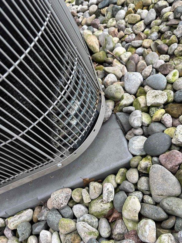 Responded to no-cooling complaint on 11-year-old residential air conditioning system. Upon arrival, confirmed unit was running but not producing adequate cool air at supply registers. Performed diagnostic assessment including temperature differential measurements at supply vents and visual inspection of outdoor condensing unit. Outdoor unit showed signs of age with moss and algae growth on surrounding landscaping, indicating potential maintenance concerns. Documented system conditions and measurements for further evaluation of refrigerant charge, airflow, and component functionality to restore proper cooling operation.