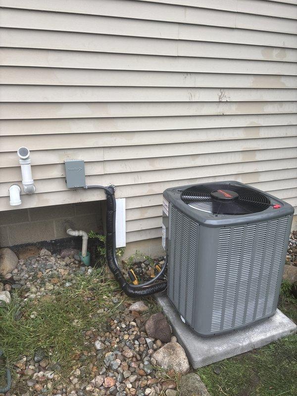 Completed full AC system replacement including outdoor condenser unit and indoor air handler. Installed new gray condenser unit on concrete pad with proper refrigerant line connections and electrical disconnect. Mounted indoor air handler with heat exchanger in crawlspace area. Established all refrigerant piping, condensate drainage via PVC, and electrical connections per manufacturer specifications. System tested and operational upon completion. Documentation photos captured for record-keeping purposes.