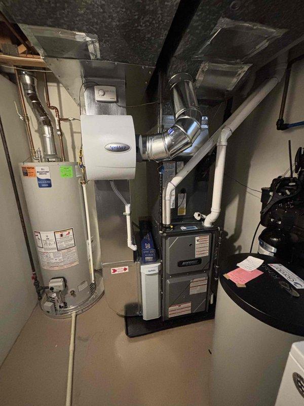 Completed full HVAC system installation including new furnace and air conditioning unit with air handler. Installed refrigerant line set with insulation and service valves, connected flexible ductwork to air handler unit positioned in attic/utility space, and integrated system with existing ductwork infrastructure. Basement furnace installation included proper venting, humidifier integration, and connection to existing water heater and utilities. All refrigerant lines capped and secured, specification labels verified, and system positioned per manufacturer requirements on concrete foundation with proper clearances maintained for service access.