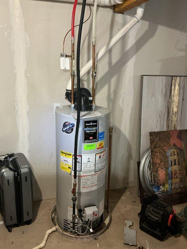 Responded to repeat service call for water heater not heating. Upon arrival, inspected white cylindrical residential water heater in basement utility area. Verified electrical connections at top of unit, including red and black wiring to wall-mounted switch box. Checked copper supply lines and white PVC venting system for proper installation and function. Diagnosed heating element failure consistent with previous service visit approximately five weeks prior. Replaced defective heating element and tested thermostat operation. Verified proper voltage supply to unit and confirmed all electrical connections secure. Cycled unit through complete heating cycle and verified hot water production. System restored to full operational status.