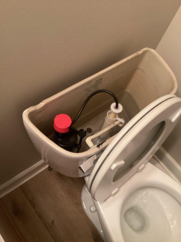 Responded to service call for two toilet issues: upstairs unit leaking from tank area and downstairs unit producing excessive noise during flush cycle. Inspected upstairs toilet tank components and identified leak source at tank-to-bowl connection. Inspected downstairs toilet flush mechanism and diagnosed worn fill valve causing loud water hammer effect. Documented internal tank components including fill valve assembly, flush valve, and float mechanism for both units.
