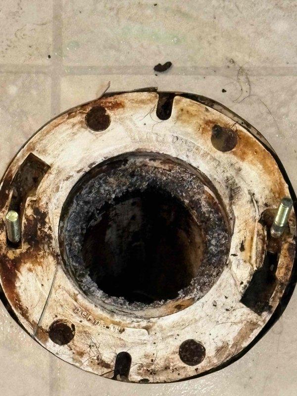Responded to a toilet service call and successfully replaced a deteriorated wax ring seal. Upon inspection, found the existing toilet flange heavily corroded with significant rust buildup and moisture damage around the mounting area. Removed toilet, scraped away old wax ring residue, cleaned the flange surface, and installed a new wax ring to restore proper seal between the toilet base and drain pipe, preventing water leakage and ensuring secure mounting.