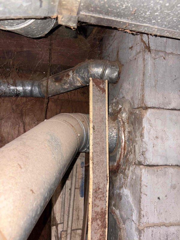 Provided water heater replacement estimate for 24-year-old unit located in basement with deteriorated insulation on existing plumbing infrastructure. Documented current conditions including aged piping, exposed joists, and utility space configuration to develop comprehensive replacement proposal.