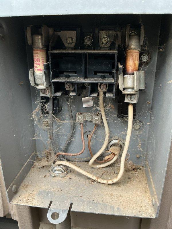 Responded to no cooling complaint on residential HVAC system. Upon inspection, found electrical disconnect box with blown fuses due to severe contamination from dirt, debris, and cobwebs causing poor electrical connection and overheating. Replaced both fuses, cleaned electrical connections and disconnect assembly, verified proper voltage and amperage at unit. System restored to normal operation with cooling confirmed.