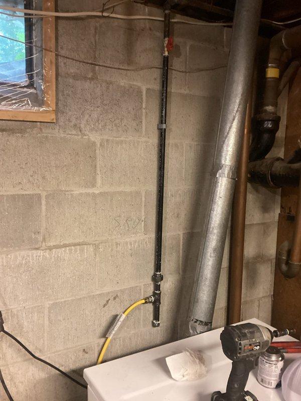 Completed project estimate for replacement of existing flexible gas line supplying clothes dryer in basement utility area. Current installation utilizes yellow CSST (Corrugated Stainless Steel Tubing) running from rigid black iron pipe connection at wall down to dryer location. Assessment identified need to replace deteriorated gas line and associated shut-off valve fitting. Documented existing conditions showing gas line routing along concrete block walls with connection points requiring updated components to meet current code requirements and ensure safe operation of gas-fired appliance.