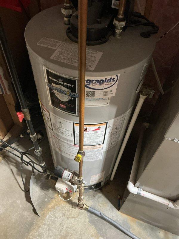 Responded to call for active water heater leak on 13-year-old Bradford White unit with previous warranty tank replacement in 2012. Upon inspection, confirmed active leak from water heater tank. Documented unit condition with photos showing installation configuration, plumbing connections, and leak source. Updated customer contact information in system as requested.