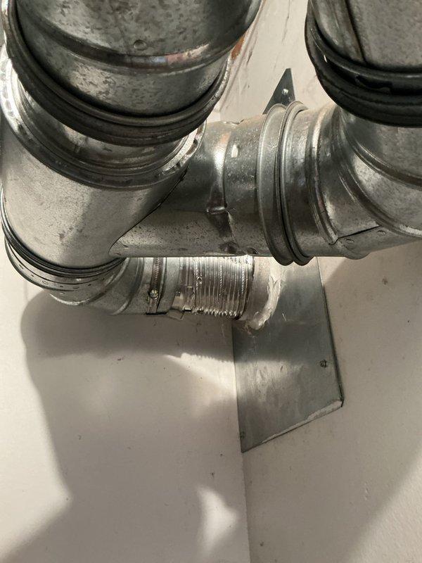 Responded to service call for deteriorated rain cap on shared furnace and water heater flue chimney. Upon roof inspection, found existing cap assembly exhibited severe rust and corrosion on metal base plate and screening components, with visible efflorescence at concrete collar connection indicating moisture intrusion. Removed old rain cap assembly from brick chimney structure and installed new rain cap with proper mesh screening to prevent water entry and debris while maintaining adequate draft for both heating appliances. Verified secure mounting and proper clearances for safe venting operation of 20-year-old furnace and water heater system.
