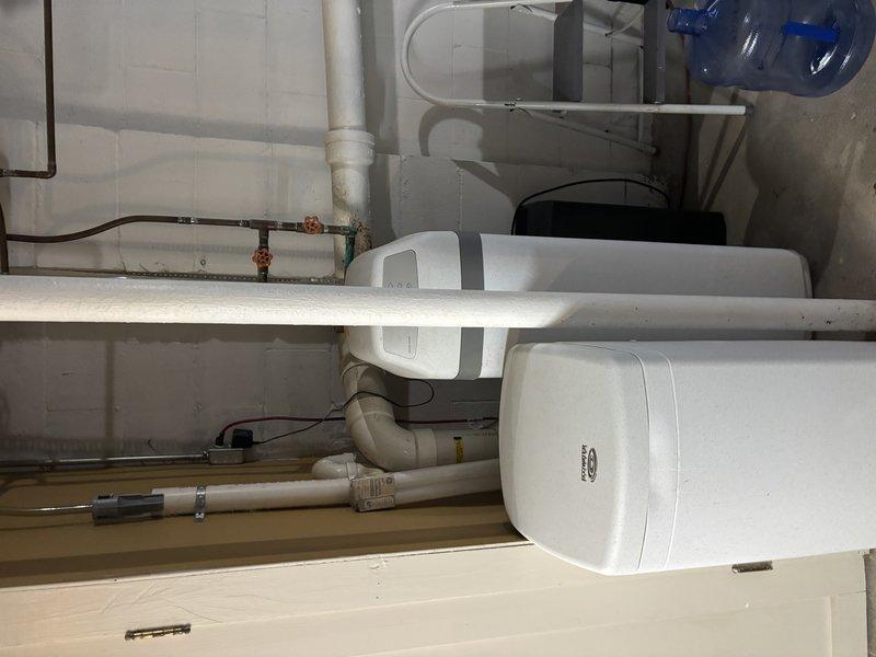 Responded to service call for leaking water heater in single-family residence. Upon arrival, inspected 7-year-old standard tank water heater and associated plumbing connections in attic space. Located active leak source and assessed surrounding copper supply lines, PVC drainage piping, and electrical connections for potential contributing factors. Documented existing plumbing infrastructure including shut-off valves, supply lines, and drain configurations. Photographed attic installation showing water heater placement, pipe routing through wooden beam structure, and proximity to electrical junction boxes. Also documented bathroom plumbing connections and emergency water collection measures in place. Completed visual inspection of all accessible components to determine extent of leak and recommend appropriate repair or replacement options to homeowner.
