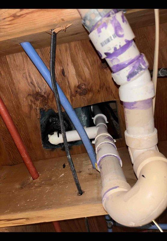 Responded to service call for first-floor bathtub leak and non-functioning sump pump. Accessed plumbing system through ceiling space below bathroom and identified source of water leak in drain assembly. Performed necessary repairs to PVC drain piping, including proper priming and fitting connections as evidenced by purple primer application at all joints. Tested bathtub for proper drainage and verified leak resolution. Sump pump issue assessed and addressed to restore functionality.