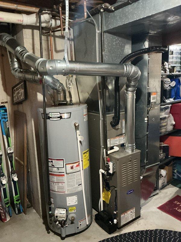 Completed full HVAC system installation including new Carrier furnace and matching outdoor condensing unit. Installed furnace in basement mechanical room with proper venting and ductwork connections, secured all refrigerant lines and electrical conduit from outdoor unit to interior equipment. Positioned outdoor AC unit on concrete pad against exterior wall with appropriate clearances, completed all electrical connections, and verified system operation upon startup.
