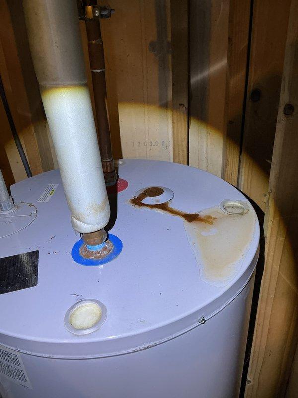 Completed annual heating system tune-up including furnace and humidifier inspection and maintenance. During inspection, documented significant rust staining on water heater top and evidence of moisture accumulation around tank base, indicating potential leak concerns that may require future attention. All heating equipment operational at time of service completion.