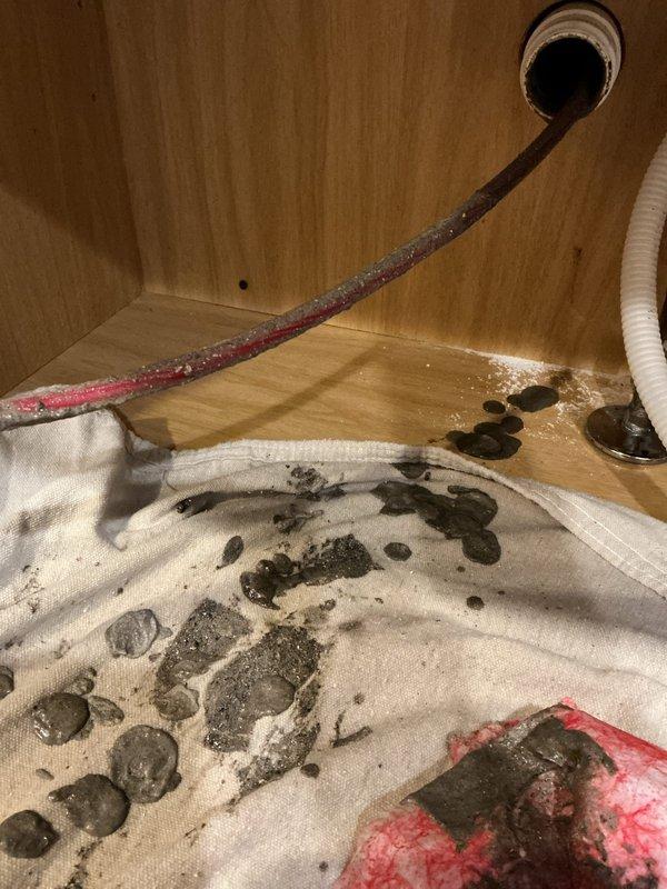 Performed camera line inspection of plumbing system using larger capacity equipment to diagnose drainage issue in water heater cabinet area. Investigation revealed significant debris accumulation beneath unit, requiring thorough documentation and assessment of waste line condition. Completed two-hour diagnostic service with photographic documentation of findings, including inspection of water heater base connections, valve assembly, and surrounding plumbing infrastructure.