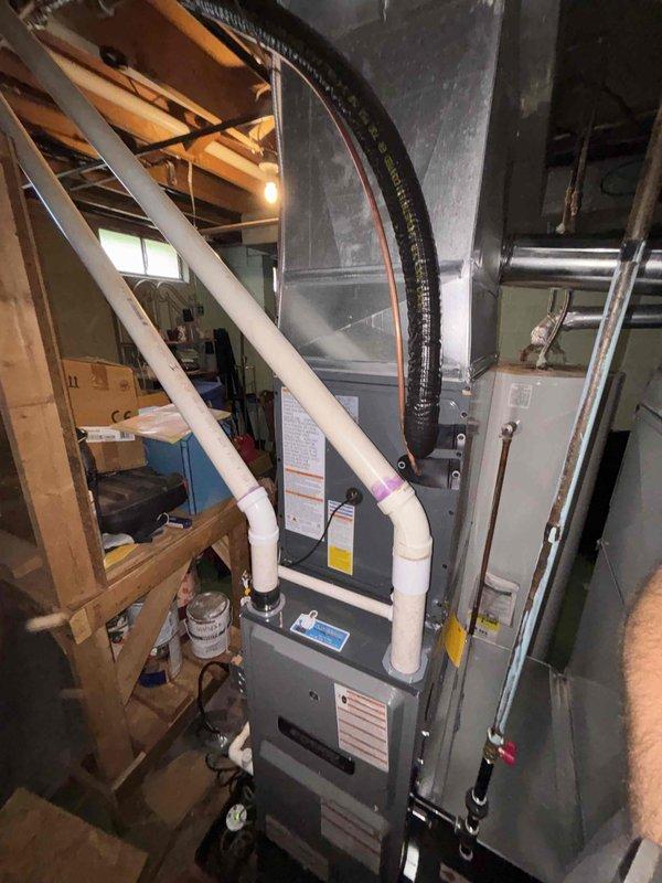 Completed full installation of new furnace and air conditioning system in basement mechanical room. Installed furnace unit with proper venting using white PVC piping, connected black flexible ductwork, and integrated AC components with system tagging for zone identification. All equipment properly labeled, mechanical connections secured, and system prepared for operation per manufacturer specifications.