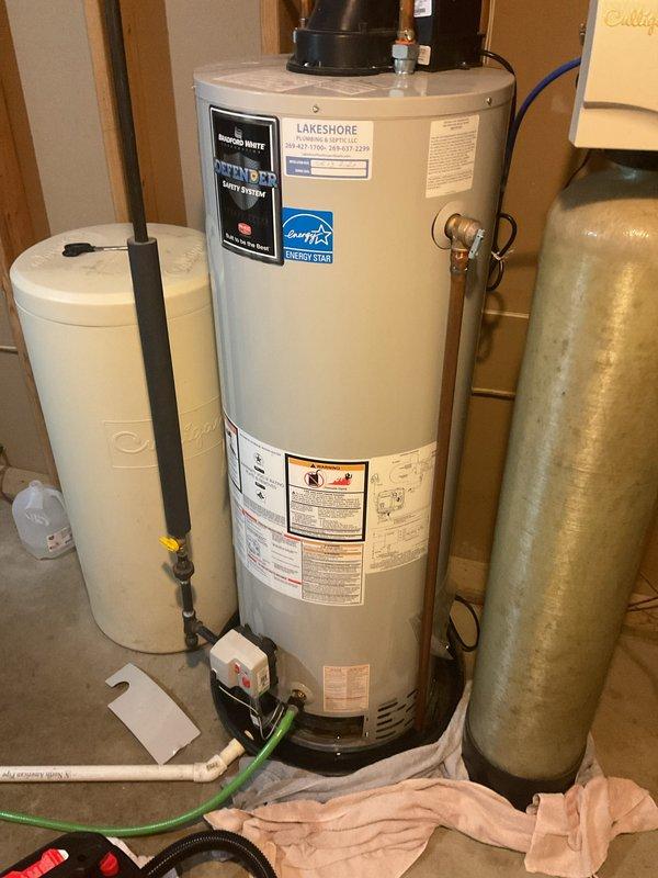 Provided estimate for water heater replacement in residential utility room. Evaluated existing Lakeshore Energy Star water heater with associated plumbing connections, expansion tank, and pressure tank system. Documented current equipment configuration including copper piping, flexible connections, and pump assembly for replacement specifications.