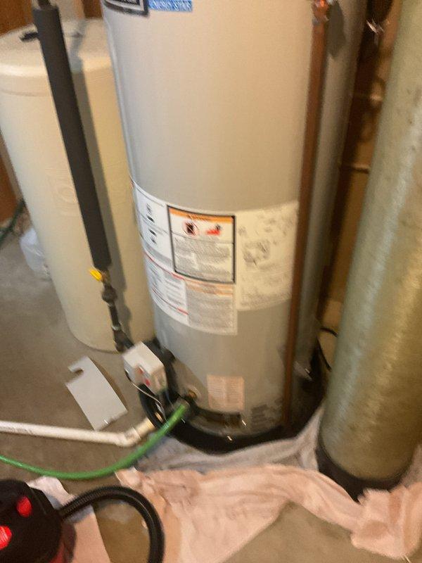 Provided estimate for water heater replacement in residential utility room. Evaluated existing Lakeshore Energy Star water heater with associated plumbing connections, expansion tank, and pressure tank system. Documented current equipment configuration including copper piping, flexible connections, and pump assembly for replacement specifications.