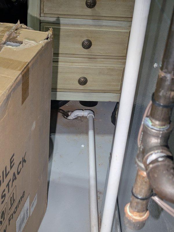 Responded to water heater leak complaint on 8-year-old Rheem unit. Upon inspection, found active leaking from bottom of tank with drip pan overflowing onto floor. Confirmed tank failure due to internal corrosion typical of unit age. Documented conditions with photos showing water accumulation in drip pan and surrounding plumbing connections. Advised customer that water heater tank has reached end of service life and requires replacement, as leaking tanks cannot be repaired.
