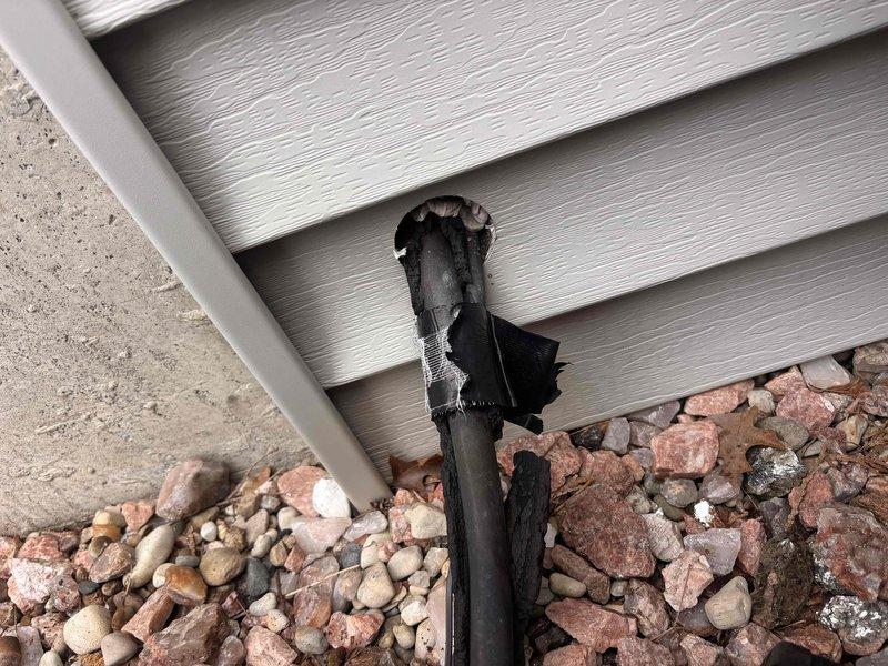 Completed annual cooling maintenance on 25-year-old Payne system. During exterior inspection, discovered severely heat-damaged condensate drain line with melted and charred PVC piping at ground level near foundation, requiring immediate attention to prevent drainage issues and potential system shutdown.