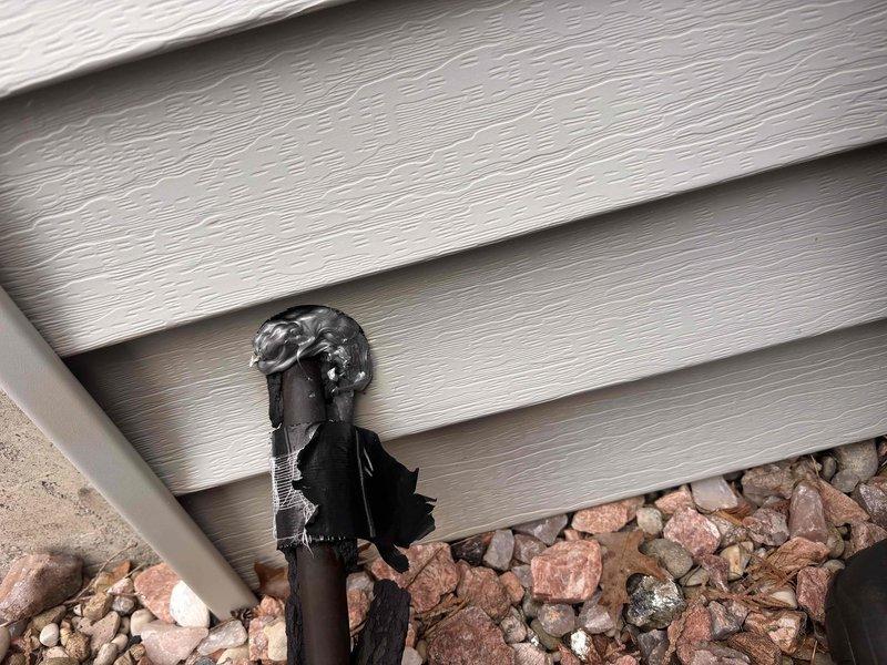 Completed annual cooling maintenance on 25-year-old Payne system. During exterior inspection, discovered severely heat-damaged condensate drain line with melted and charred PVC piping at ground level near foundation, requiring immediate attention to prevent drainage issues and potential system shutdown.
