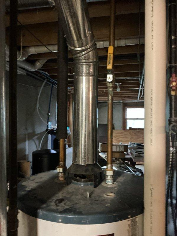 Responded to service call for non-functional water heater igniter on 20-year-old residential unit. Upon inspection, documented existing equipment condition and configuration in basement utility area, including water heater installation with standard venting and piping connections. Confirmed best contact number with customer for future service needs and completed photographic documentation of the equipment and installation for service records.