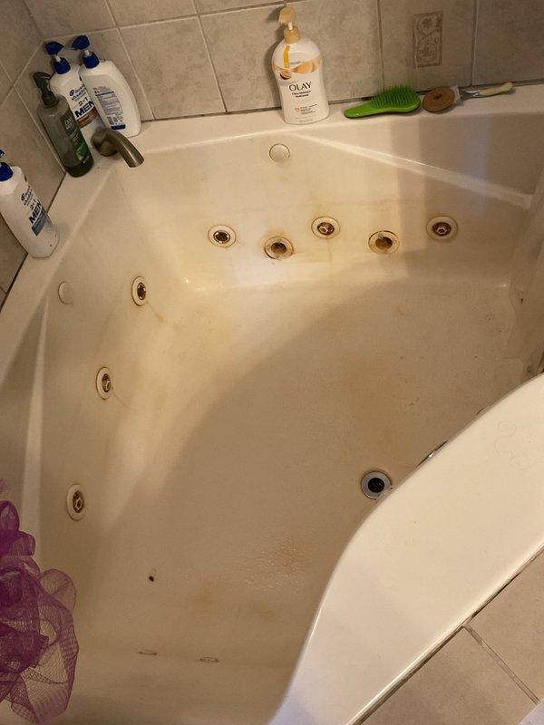 Completed paid plumbing inspection to investigate reported ceiling leak suspected to originate from copper piping. Documented extensive water damage and staining on interior ceiling with discoloration patterns indicating active or recent moisture intrusion. Inspected bathroom fixtures including jetted tub showing water staining and discoloration on surfaces, suggesting potential leak source in proximity to damaged ceiling area below.