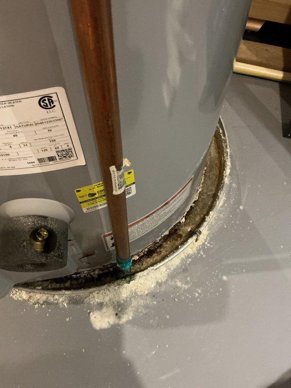 Completed annual heating and cooling tune-up service on two 5-year-old Trane units, furnace, and water heater. Inspected and serviced AC system, air handler, and furnace per manufacturer specifications; no humidifier present on system. Documented significant mineral deposit buildup and corrosion at water heater base indicating active or previous leakage requiring attention. Noted substantial dust and debris accumulation on blower assembly components within air handler unit. Photographed conditions for customer records and recommended addressing water heater leakage issue and scheduling thorough cleaning of HVAC blower components to maintain system efficiency and prevent premature equipment failure.