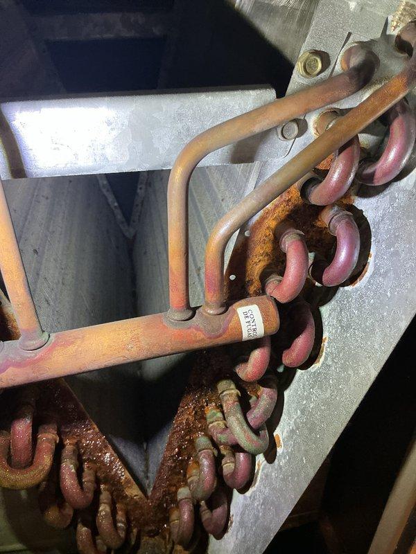 Completed annual cooling maintenance on 18-year-old Carrier AC system. Performed comprehensive tune-up including inspection of blower motor assembly, electrical connections, and refrigerant lines. Observed significant dust accumulation on blower motor housing and surrounding components, along with oxidation and corrosion on copper refrigerant tubing and deteriorated line insulation. All electrical terminals and wire connections at motor inspected and found secure. System operational at time of service completion. Documented equipment condition with photographs for service records.