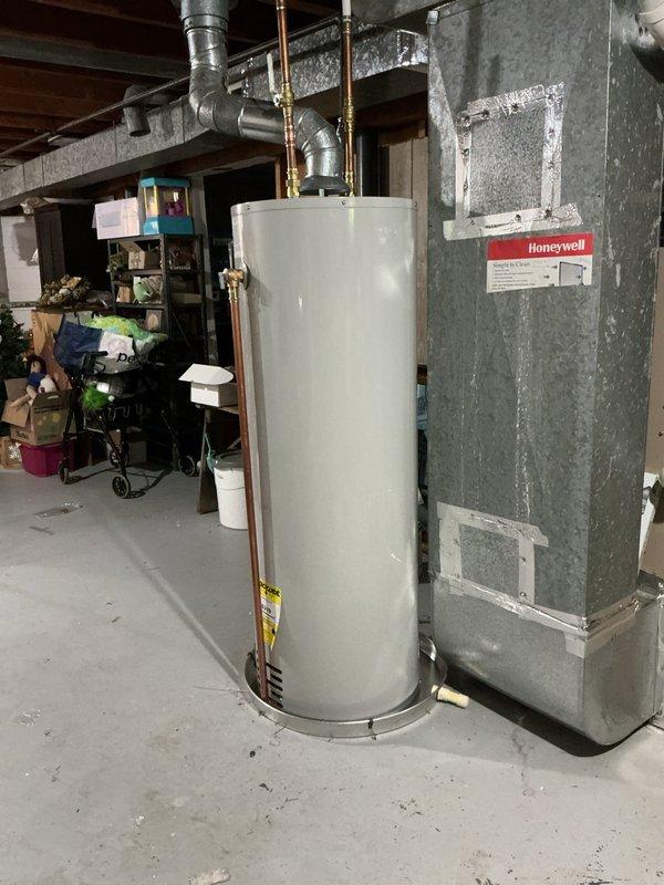 Successfully installed a 40-gallon natural draft natural gas water heater (Bradford White model BW BS516125T) in the basement mechanical room. The tall tank unit (56 5/8") was positioned on the concrete floor with proper clearances, connected to existing copper supply lines, and vented through metal exhaust ductwork extending to the ceiling joists. Installation includes 6-year parts and 1-year labor warranty coverage.