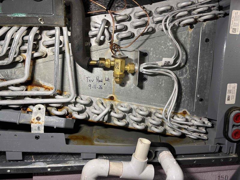 Replaced defective thermostatic expansion valve (TXV) on HVAC unit. Removed old valve, installed new brass TXV with proper torque specifications, reconnected refrigerant lines and electrical connections, and verified system operation. Unit tested and left in working order with completed work notation dated 9-1-26 marked on equipment panel.