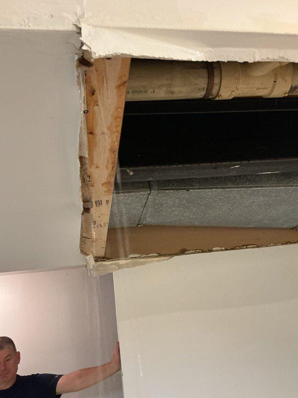 Responded to a drain-related service call that required accessing concealed plumbing infrastructure through ceiling and wall cavities. Created necessary access openings in the ceiling and interior wall to expose and address drainage system components, including ductwork and piping running through the structural framing. Successfully diagnosed and resolved the plumbing issue affecting the concealed drain lines within the building envelope.