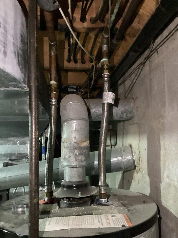 Responded to no hot water complaint on 13-year-old Kenmore water heater. Upon inspection, found unit with corroded components and aging flexible supply lines with brass fittings showing wear consistent with age. Evaluated water heater system including tank condition, piping connections, and mechanical components in basement utility area. Documented equipment condition with photos showing deteriorated cylinder assembly, braided metal flex lines, and associated plumbing infrastructure. Customer contacted for approval on necessary repairs or replacement options given age and condition of unit.