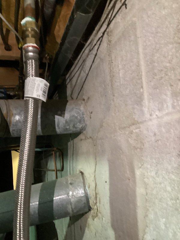 Responded to no hot water complaint on 13-year-old Kenmore water heater. Upon inspection, found unit with corroded components and aging flexible supply lines with brass fittings showing wear consistent with age. Evaluated water heater system including tank condition, piping connections, and mechanical components in basement utility area. Documented equipment condition with photos showing deteriorated cylinder assembly, braided metal flex lines, and associated plumbing infrastructure. Customer contacted for approval on necessary repairs or replacement options given age and condition of unit.