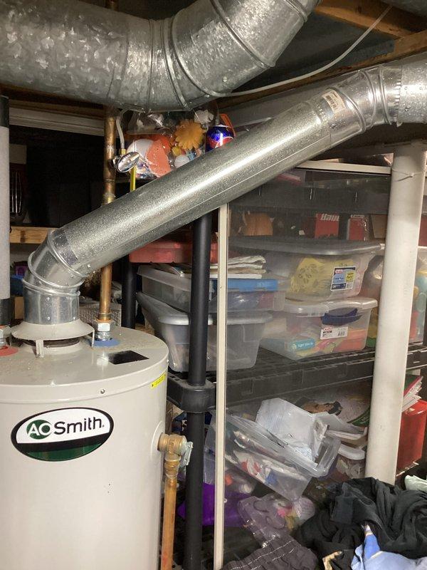 Responded to no hot water complaint on 14-year-old AO Smith water heater. Upon arrival, performed diagnostic inspection of unit and surrounding utility area. Documented existing conditions including water heater installation, associated plumbing connections with copper fittings and black PVC piping, and overhead ductwork system in basement location. Completed visual assessment and photographic documentation of equipment for service records.
